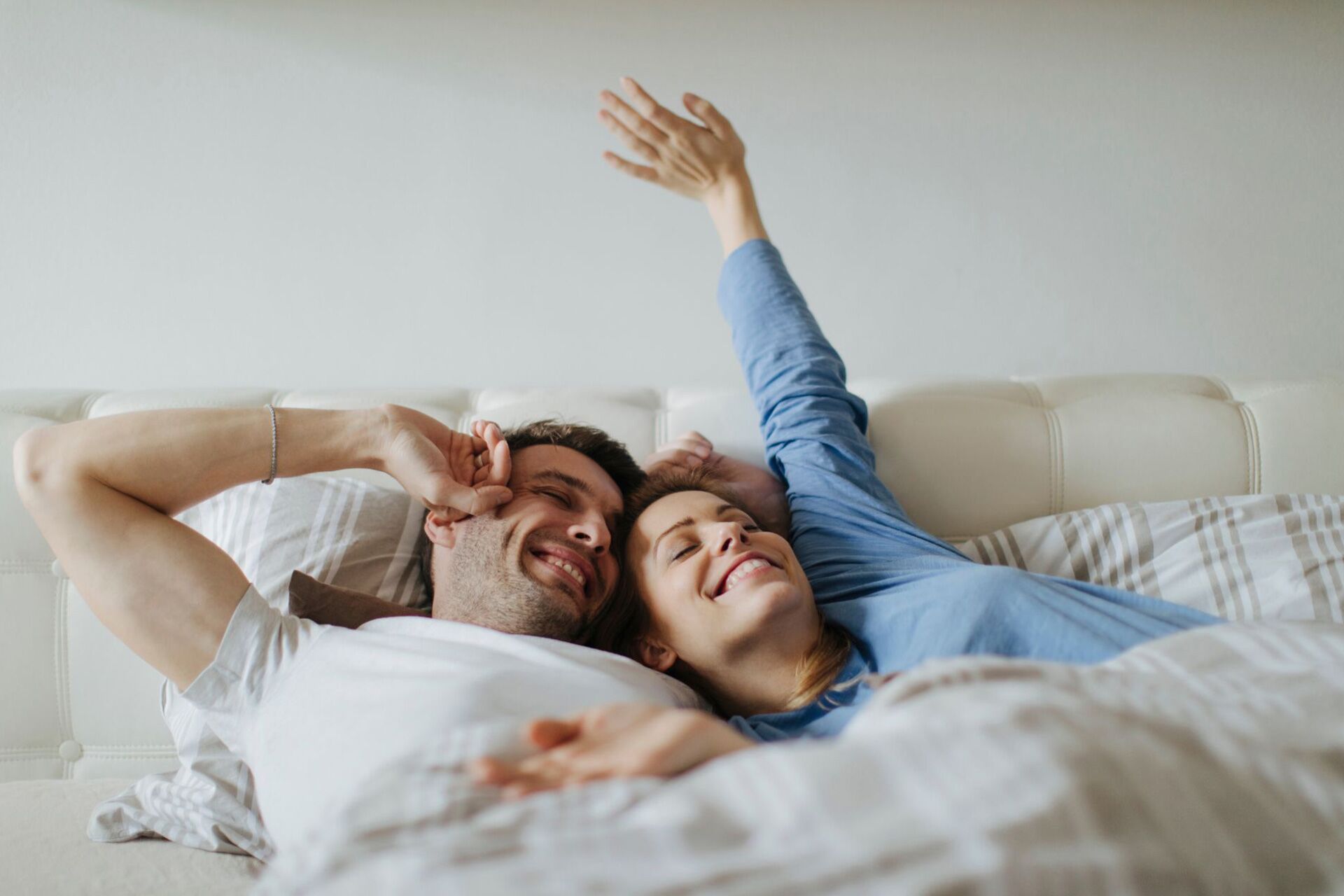 A couple waking up happily in bed