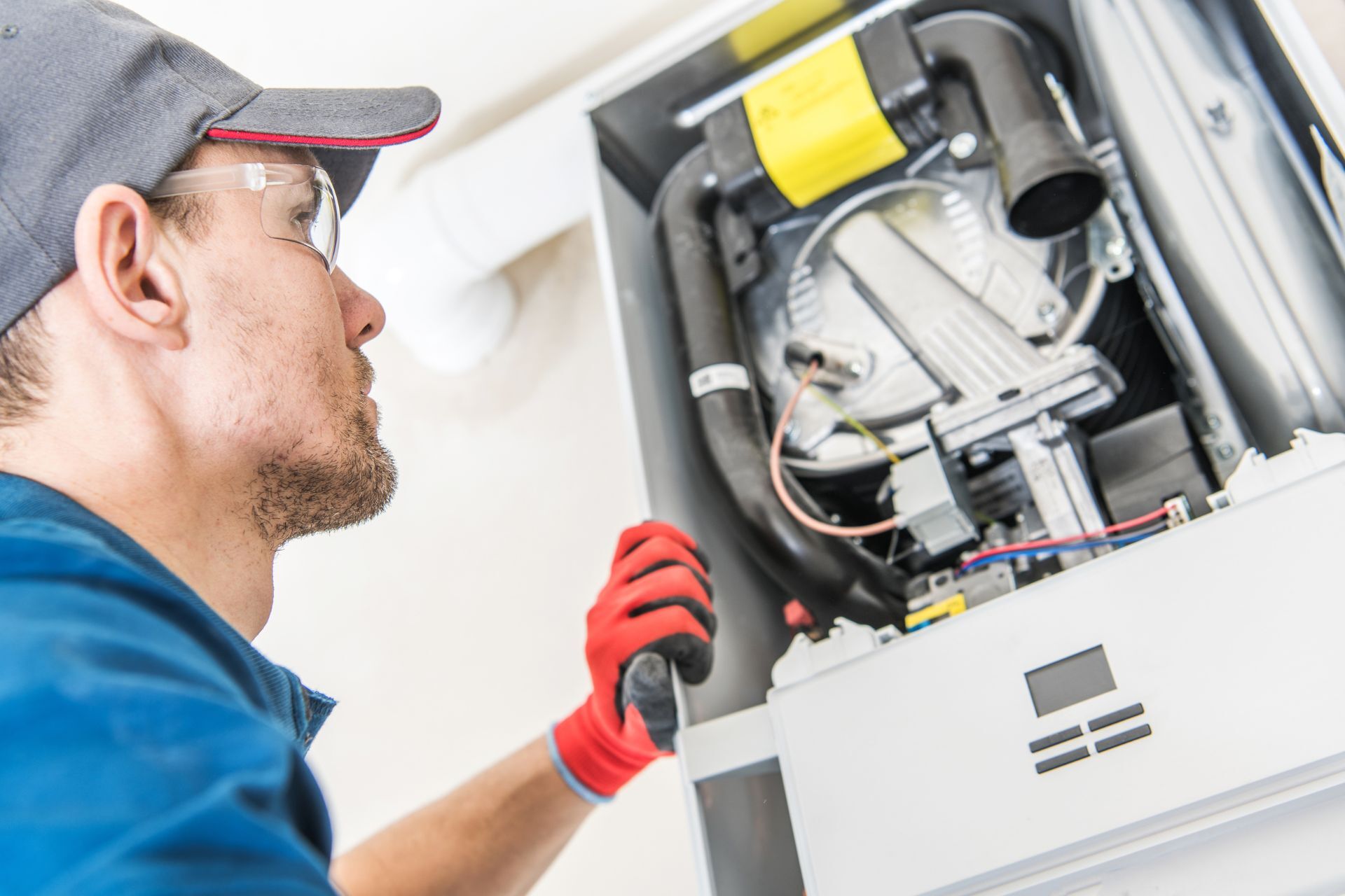 An HVAC Technician Inspecting a Furnace - LG Home Comfort